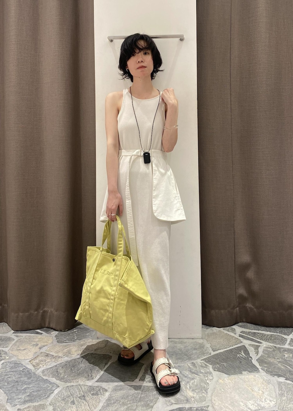 ホワイト系のワンピース、イエロー系のトートバッグ、ホワイト系のベルトを着用したレディースの春コーディネートの2枚目の写真