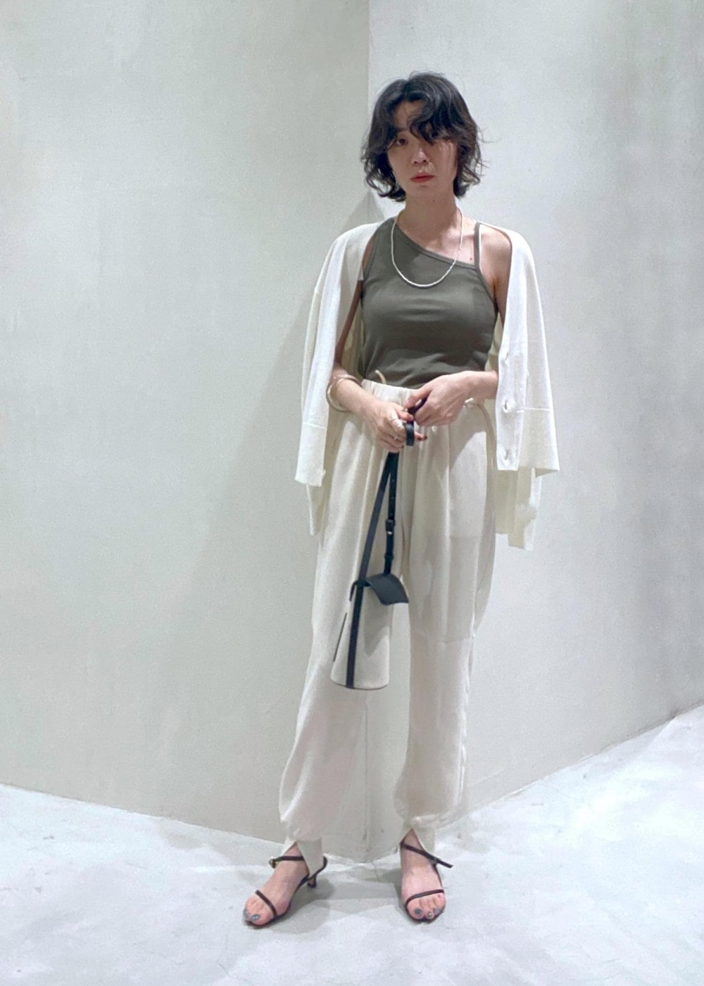 ホワイト系のその他パンツ、グリーン系のキャミソール、ホワイト系のカーディガン/ボレロを着用したレディースの夏コーディネートの2枚目の写真