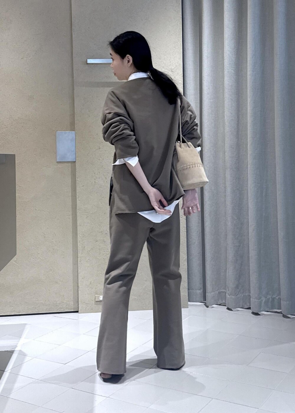 ホワイト系のシャツ/ブラウス、ホワイト系のショルダーバッグ、ブラウン系のスウェットを着用したレディースの春コーディネートの3枚目の写真