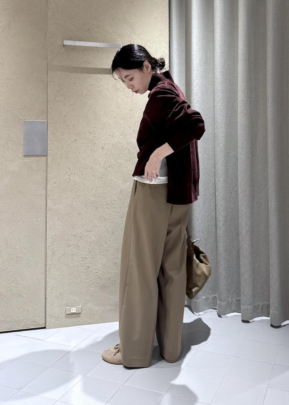 ホワイト系のTシャツ/カットソー、ベージュ系のスラックス、ブラウン系のショルダーバッグを着用したレディースの秋コーディネートの5枚目の写真