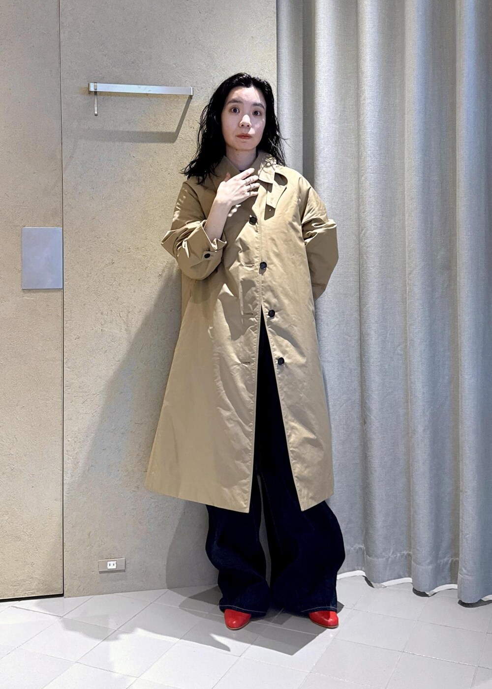 ベージュ系のダウンジャケット/コート、レッド系のパンプス、ブルー系のデニムパンツを着用したレディースの秋コーディネートの2枚目の写真