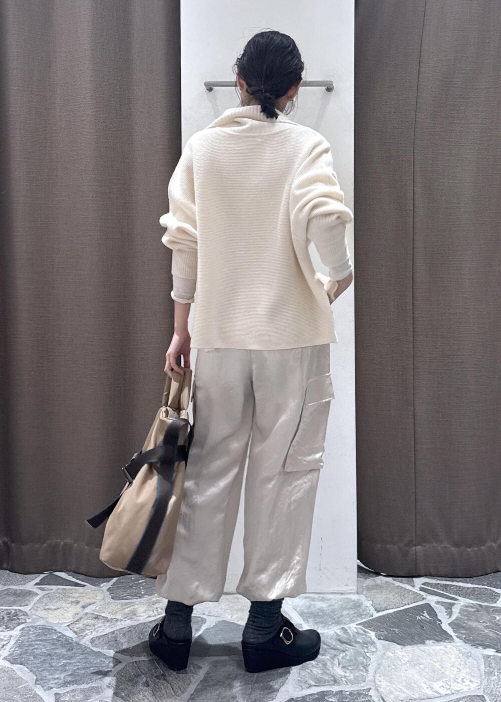 ホワイト系のカーディガン/ボレロ、ホワイト系のカーゴパンツ、ベージュ系のトートバッグを着用したレディースの冬コーディネートの5枚目の写真