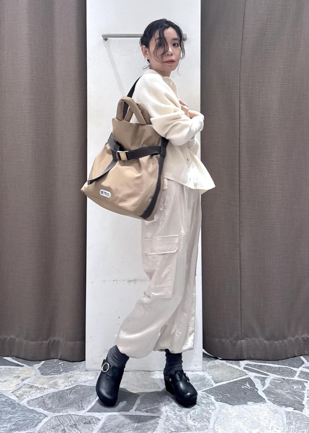 ホワイト系のカーディガン/ボレロ、ホワイト系のカーゴパンツ、ベージュ系のトートバッグを着用したレディースの冬コーディネートの4枚目の写真