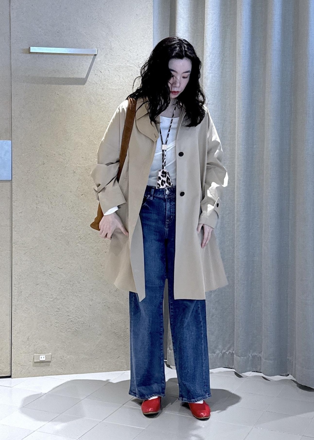 ブルー系のデニムパンツ、ホワイト系のTシャツ/カットソー、ベージュ系のステンカラーコートを着用したレディースの冬コーディネートの5枚目の写真