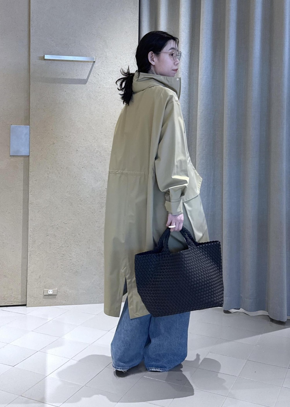 ベージュ系のミリタリージャケット、グレー系のTシャツ/カットソー、ブラック系のトートバッグを着用したレディースの春コーディネートの4枚目の写真