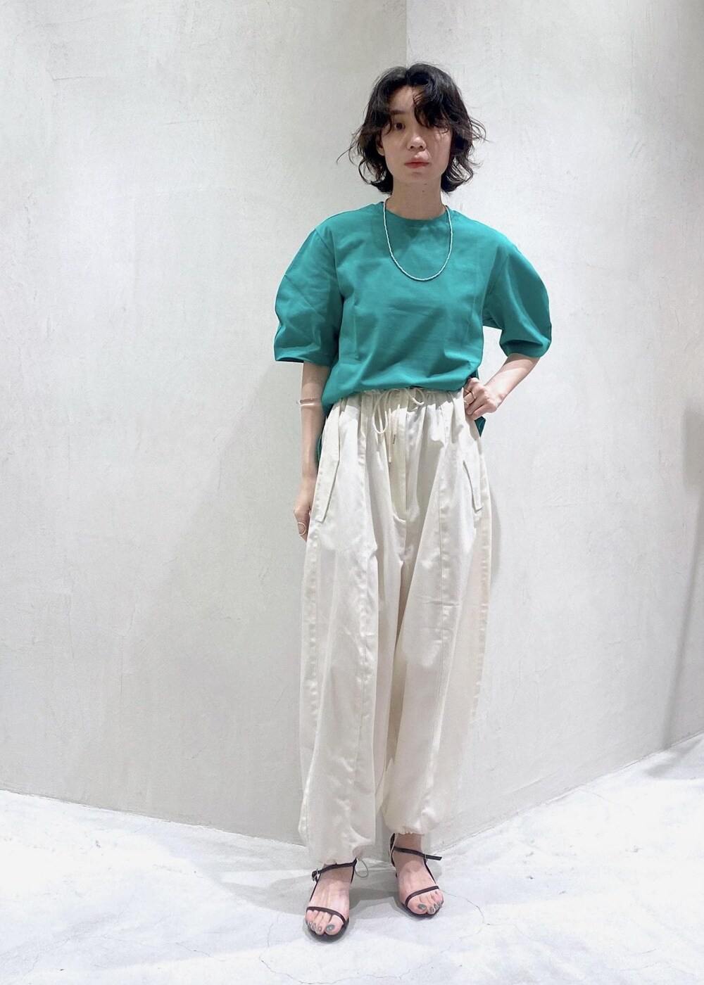 ホワイト系のカーゴパンツ、グリーン系のTシャツ/カットソーを着用したレディースの夏コーディネートの3枚目の写真