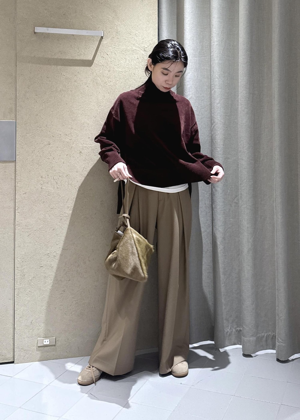 ホワイト系のTシャツ/カットソー、ベージュ系のスラックス、ブラウン系のショルダーバッグを着用したレディースの秋コーディネートの3枚目の写真