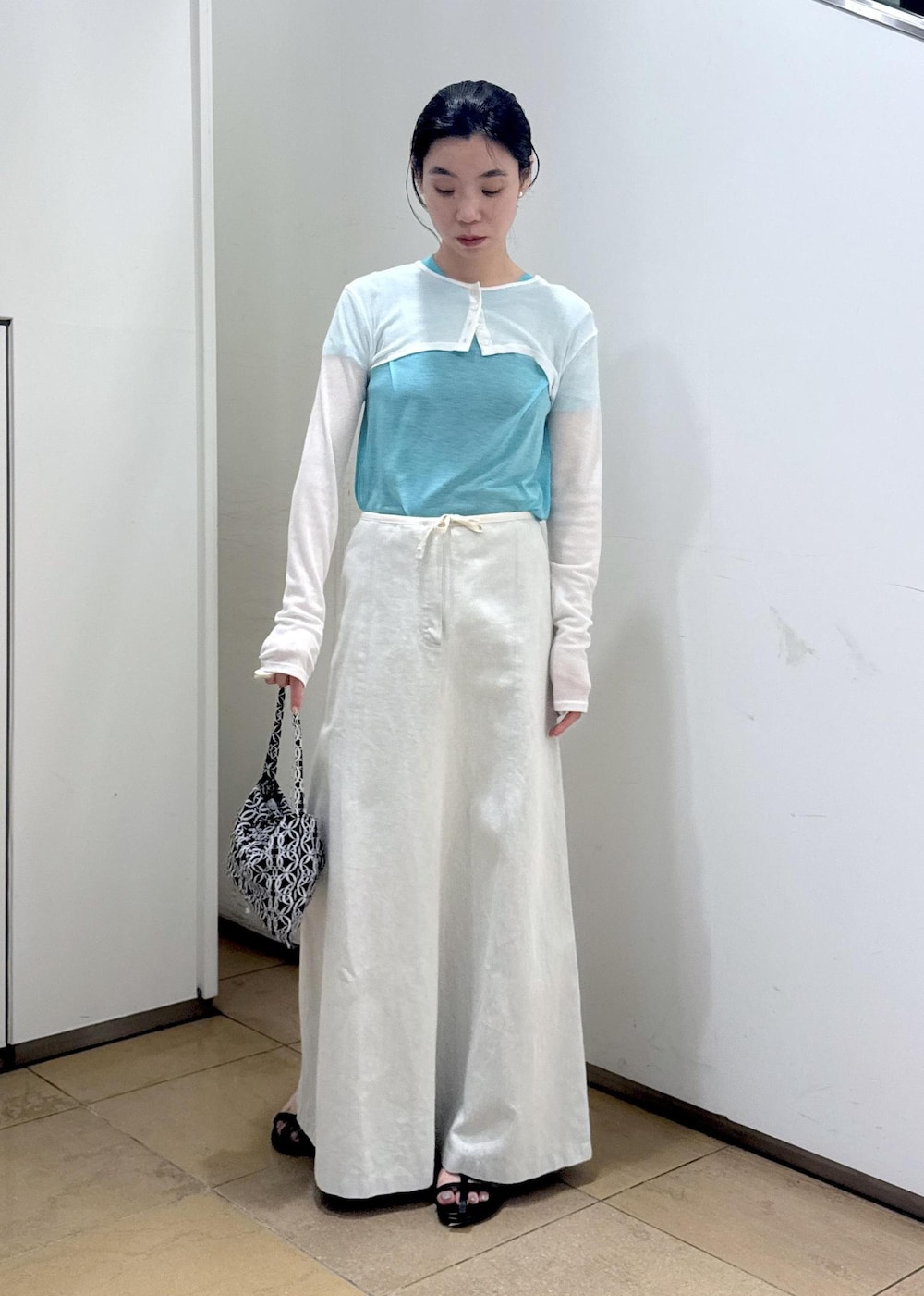 ブラック系のサンダル、ホワイト系のカーディガン/ボレロ、ブルー系のTシャツ/カットソーを着用したレディースの夏コーディネートの4枚目の写真