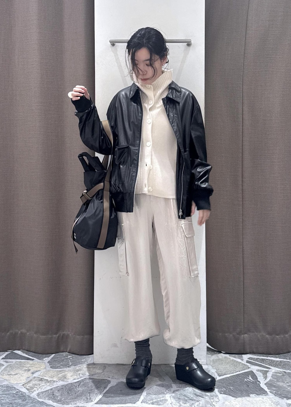 ホワイト系のカーゴパンツ、ブラック系のブルゾン、ホワイト系のカーディガン/ボレロを着用したレディースの冬コーディネートの5枚目の写真
