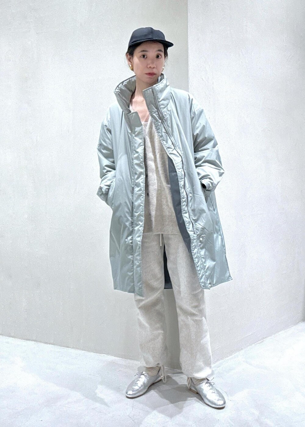 ホワイト系のカーディガン/ボレロ、シルバー系のその他アウター、ブラック系のキャップを着用したレディースの冬コーディネートの2枚目の写真