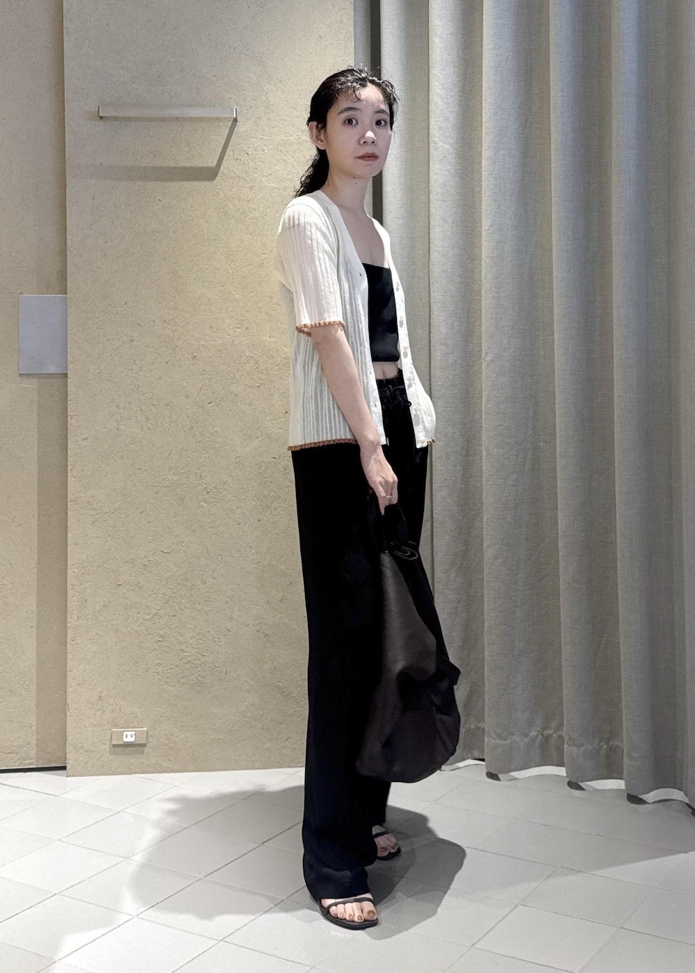 ブラック系のその他パンツ、ホワイト系のカーディガン/ボレロ、ブラウン系のトートバッグを着用したレディースの夏コーディネートの2枚目の写真
