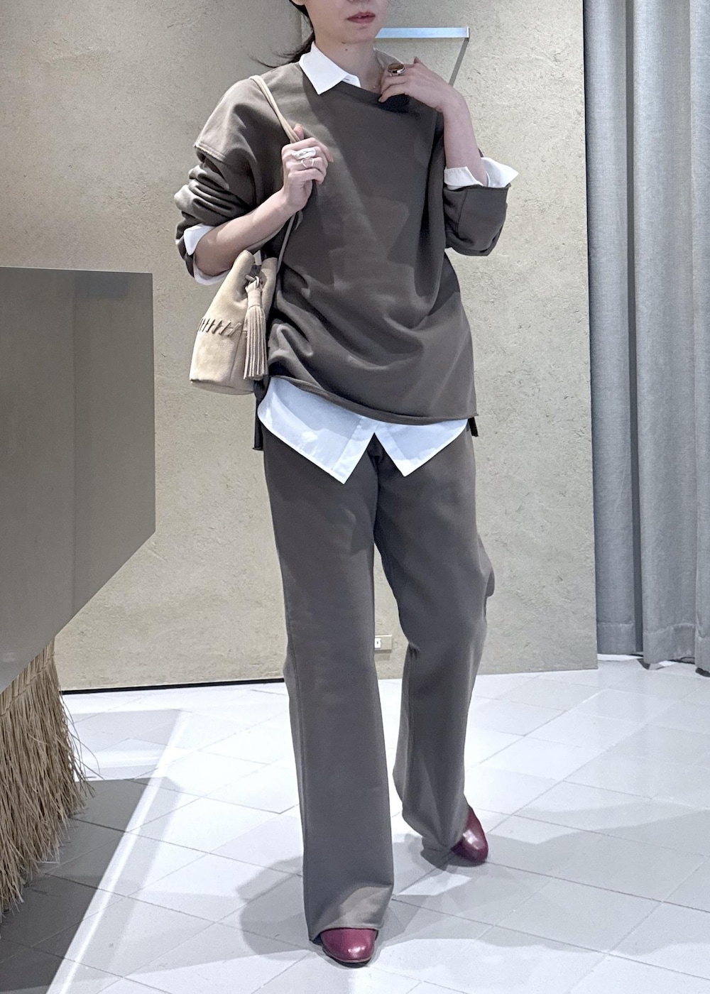 ホワイト系のシャツ/ブラウス、ホワイト系のショルダーバッグ、ブラウン系のスウェットを着用したレディースの春コーディネートの2枚目の写真