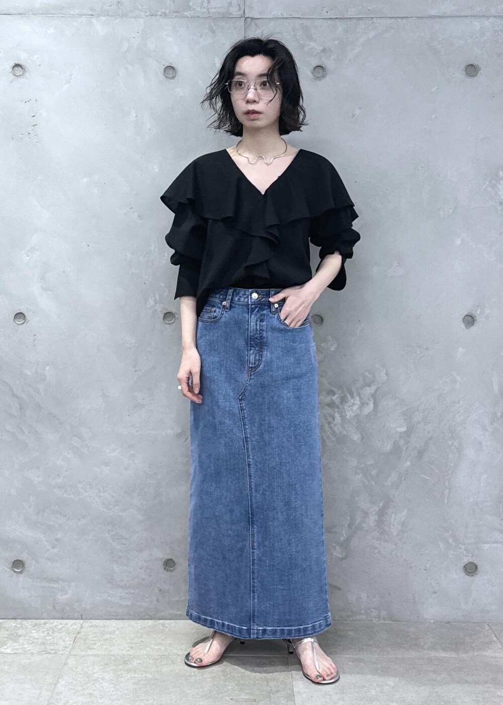 ブラック系のシャツ/ブラウス、ブルー系のデニムスカートを着用したレディースの春コーディネートの3枚目の写真