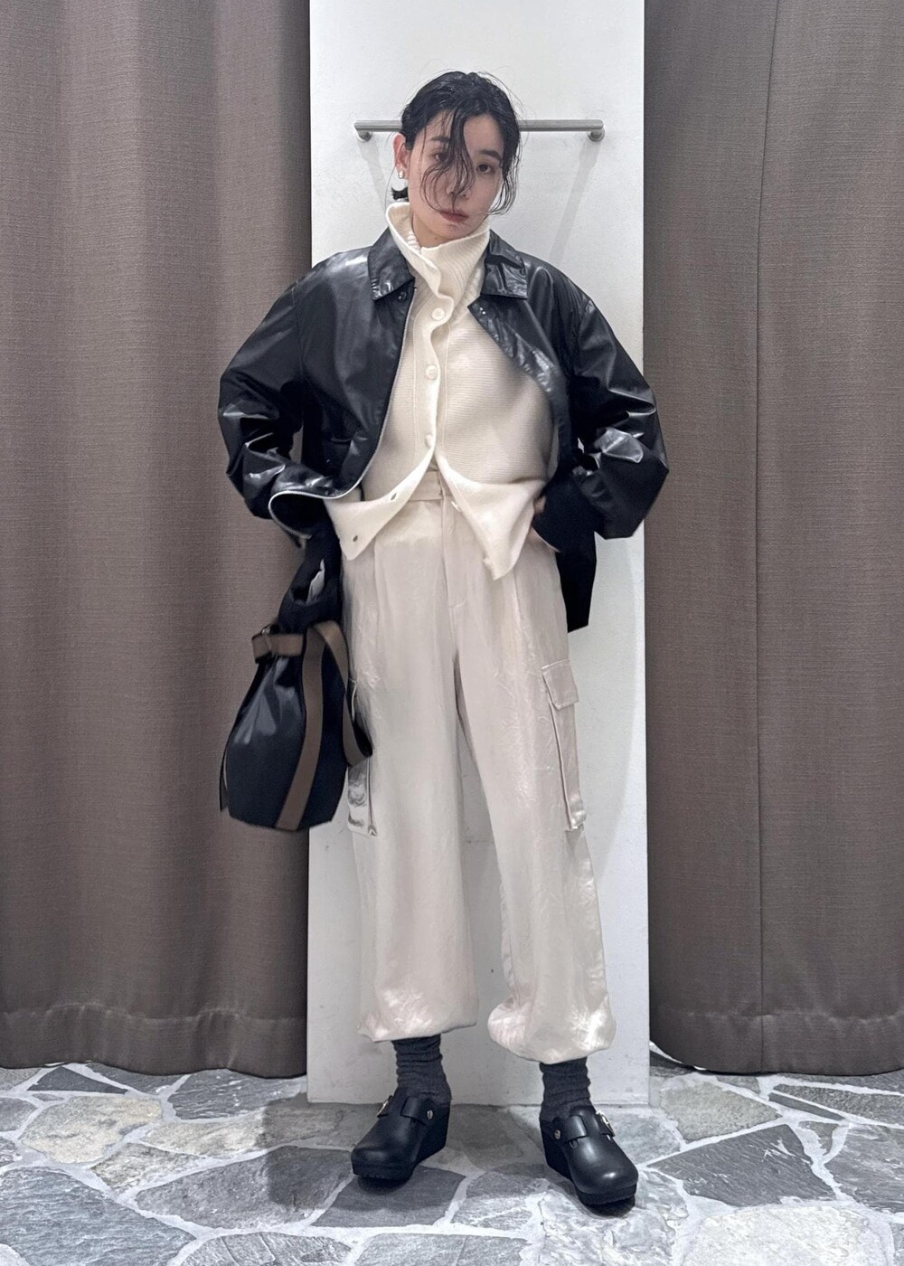 ホワイト系のカーゴパンツ、ブラック系のブルゾン、ホワイト系のカーディガン/ボレロを着用したレディースの冬コーディネートの7枚目の写真