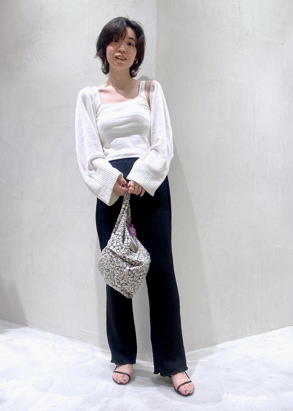 ホワイト系のカーディガン/ボレロ、ブラック系のトートバッグ、ブラック系のその他パンツを着用したレディースの夏コーディネートの2枚目の写真