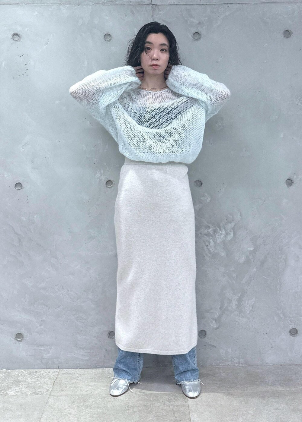 ホワイト系のスカート、ブルー系のニット/セーター、ブルー系のデニムパンツを着用したレディースの秋コーディネートの5枚目の写真