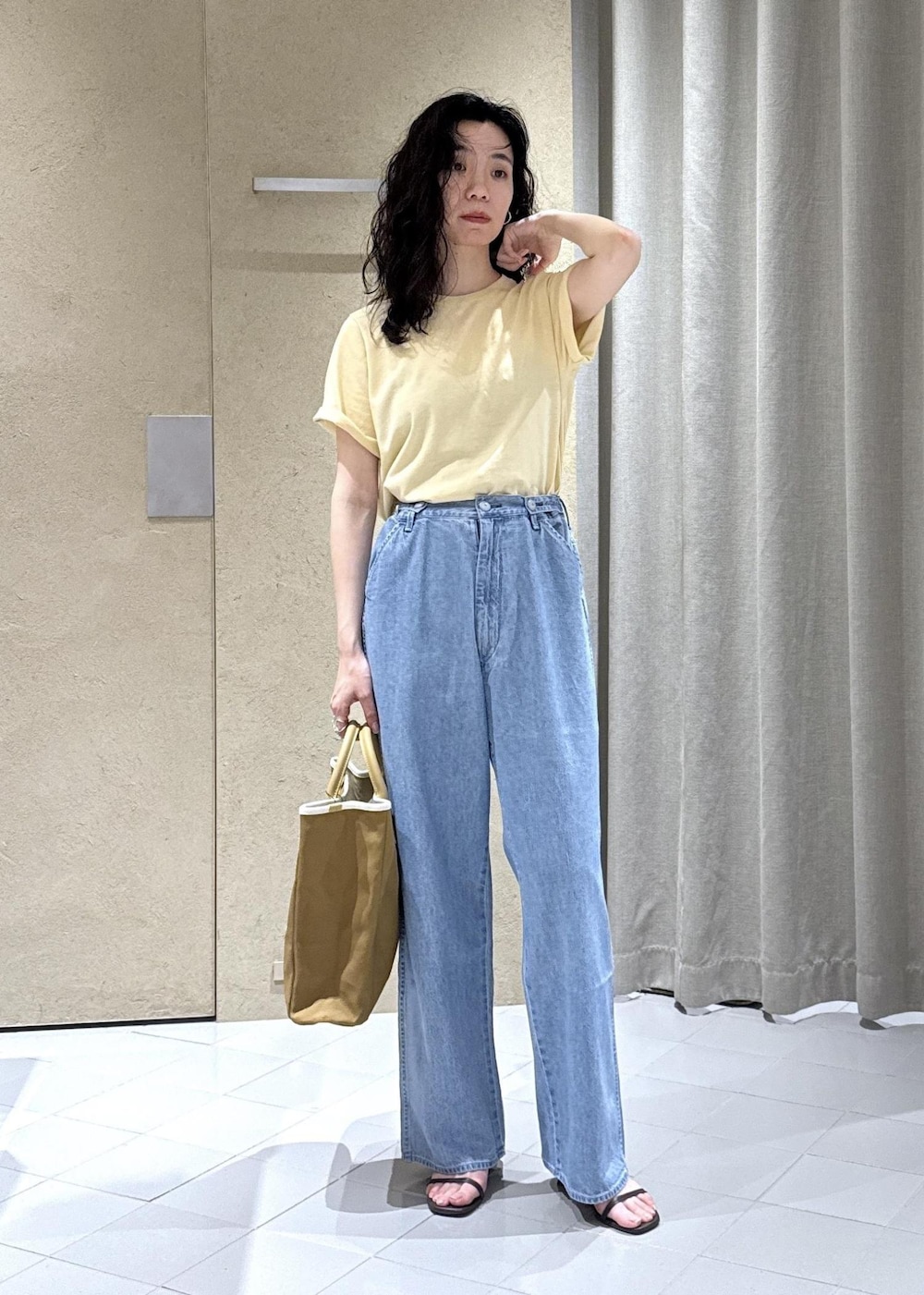 ホワイト系のTシャツ/カットソー、ブルー系のデニムパンツ、ベージュ系のトートバッグを着用したレディースの夏コーディネートの5枚目の写真