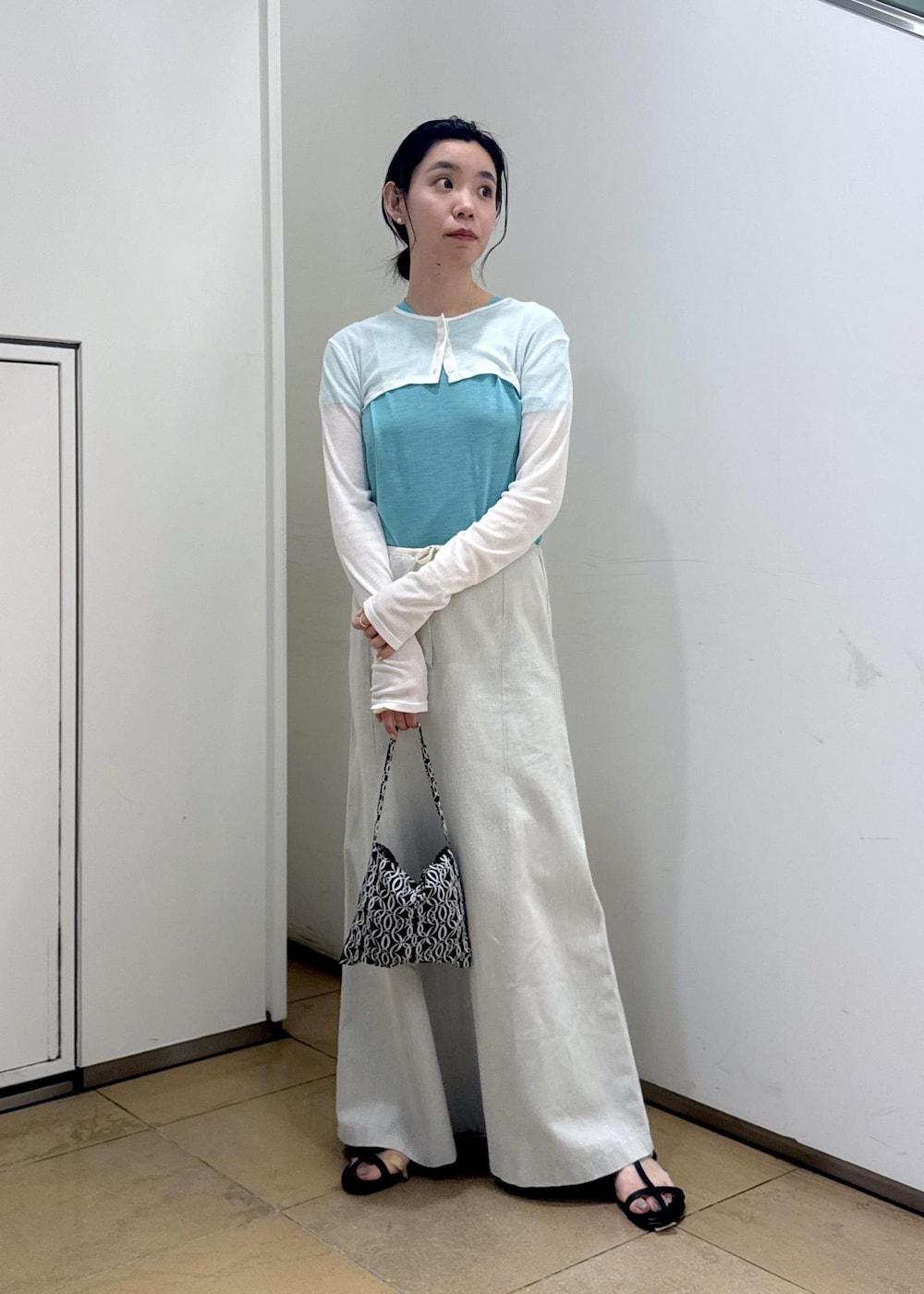 ブラック系のサンダル、ホワイト系のカーディガン/ボレロ、ブルー系のTシャツ/カットソーを着用したレディースの夏コーディネートの2枚目の写真