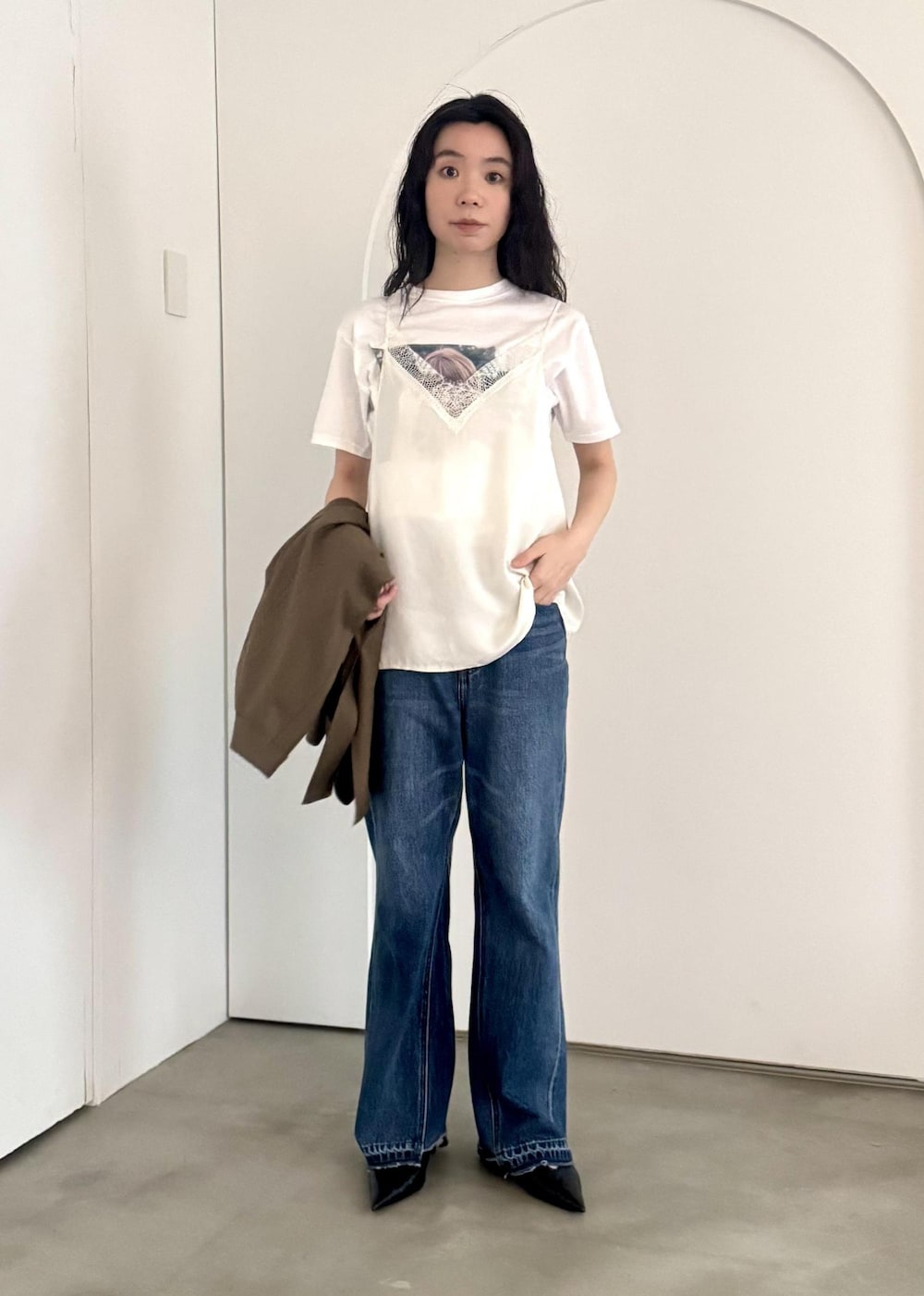 ブルー系のデニムパンツ、ホワイト系のキャミソール、ホワイト系のTシャツ/カットソーを着用したレディースの冬コーディネートの4枚目の写真