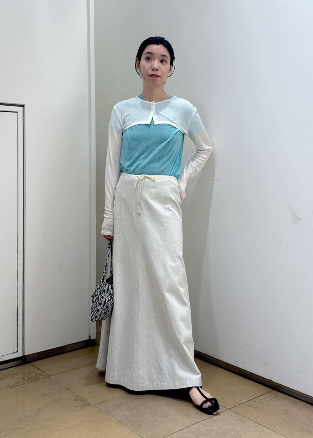 ブラック系のサンダル、ホワイト系のカーディガン/ボレロ、ブルー系のTシャツ/カットソーを着用したレディースの夏コーディネートの3枚目の写真