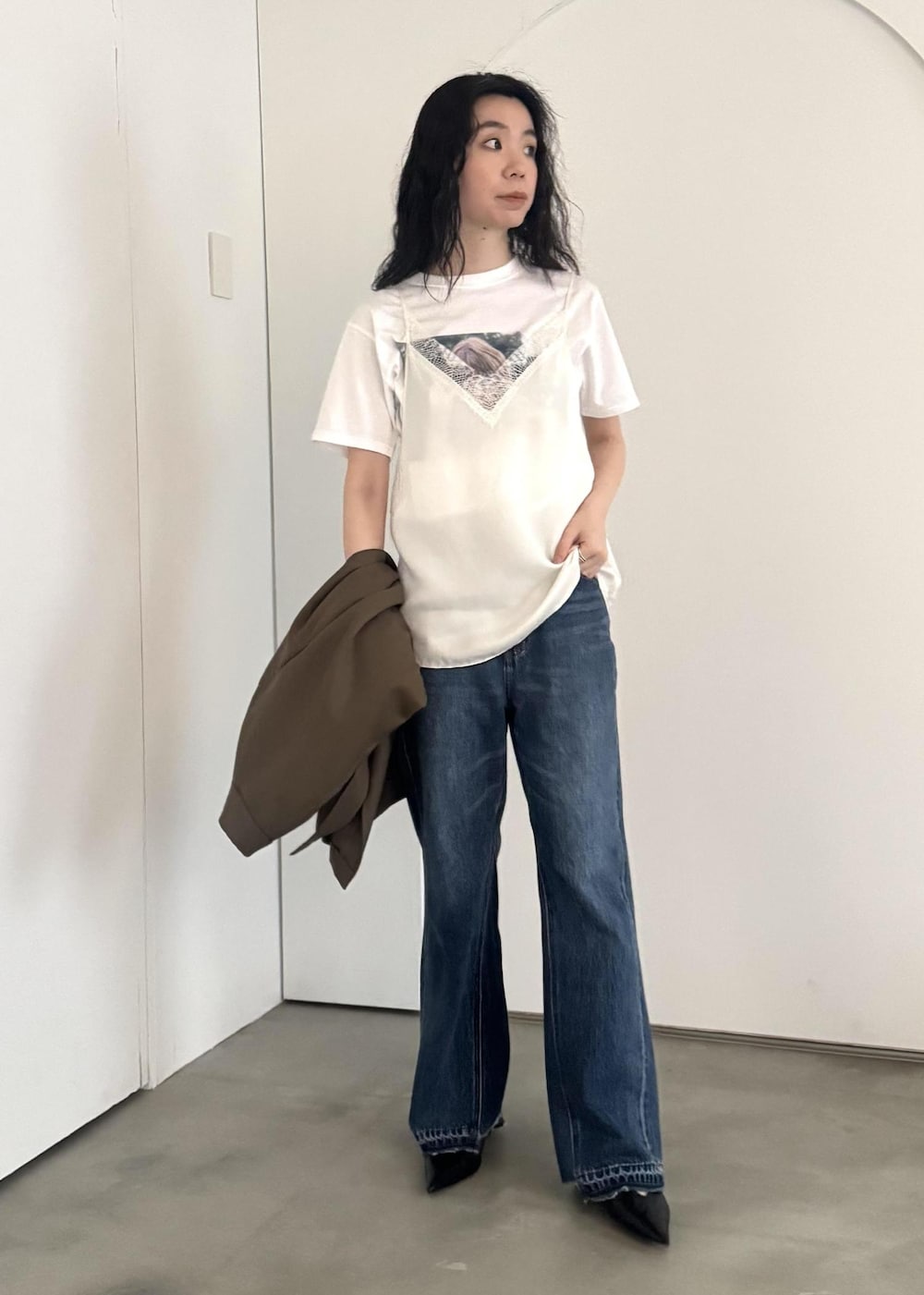 ブルー系のデニムパンツ、ホワイト系のキャミソール、ホワイト系のTシャツ/カットソーを着用したレディースの冬コーディネートの2枚目の写真