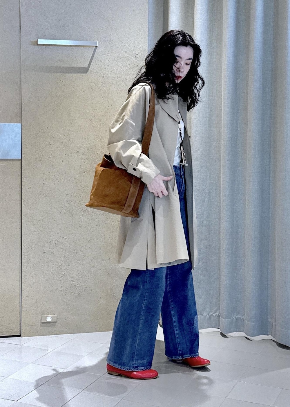 ブルー系のデニムパンツ、ホワイト系のTシャツ/カットソー、ベージュ系のステンカラーコートを着用したレディースの冬コーディネートの6枚目の写真