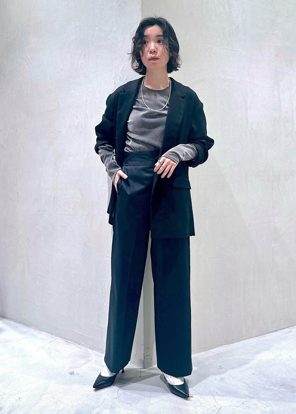 グレー系のTシャツ/カットソー、ブラック系のその他パンツ、ブラック系のテーラードジャケットを着用したレディースの冬コーディネートの2枚目の写真