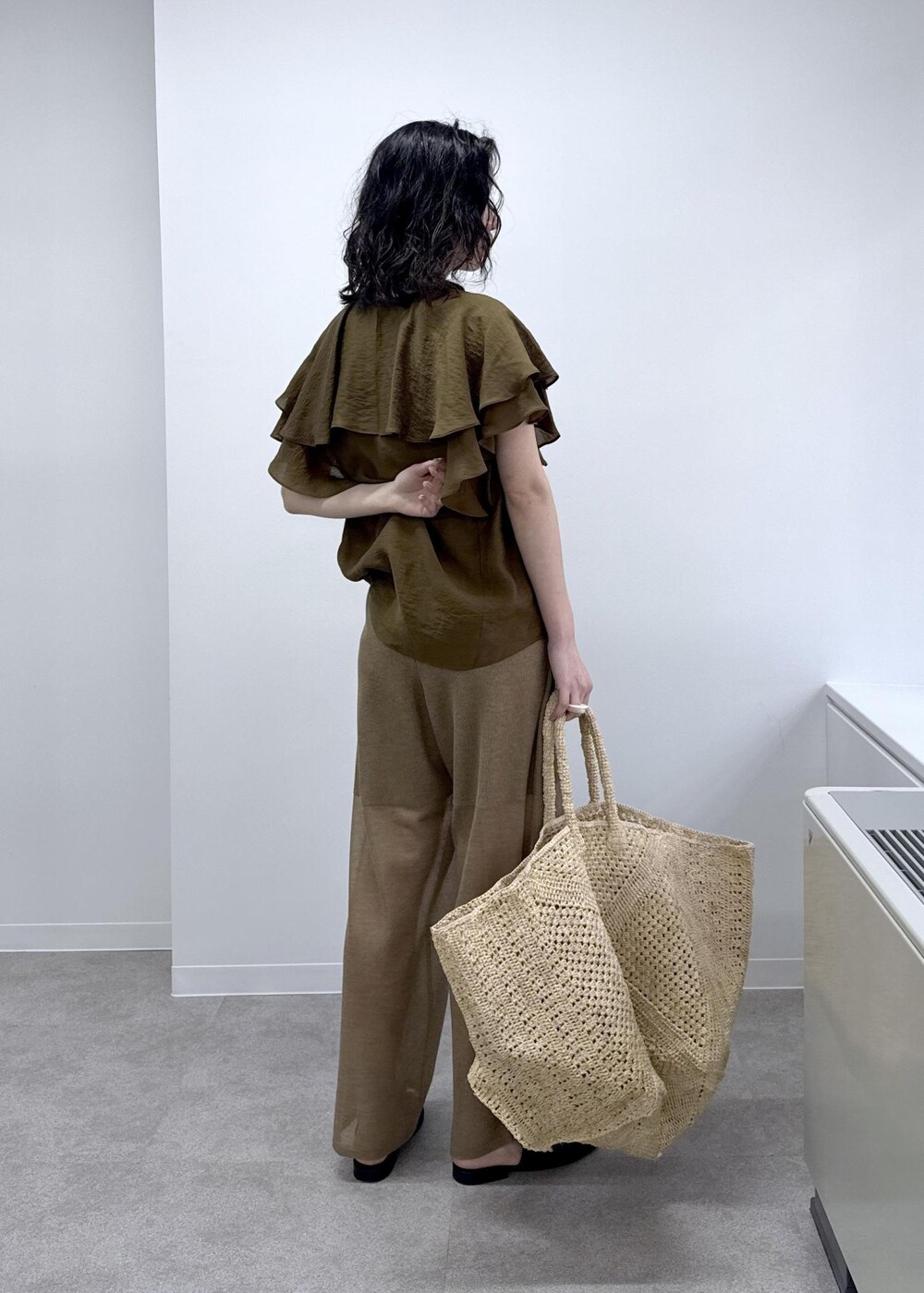 ホワイト系のかごバッグ、ブラウン系のシャツ/ブラウス、ゴールド系のその他パンツを着用したレディースの春コーディネートの3枚目の写真