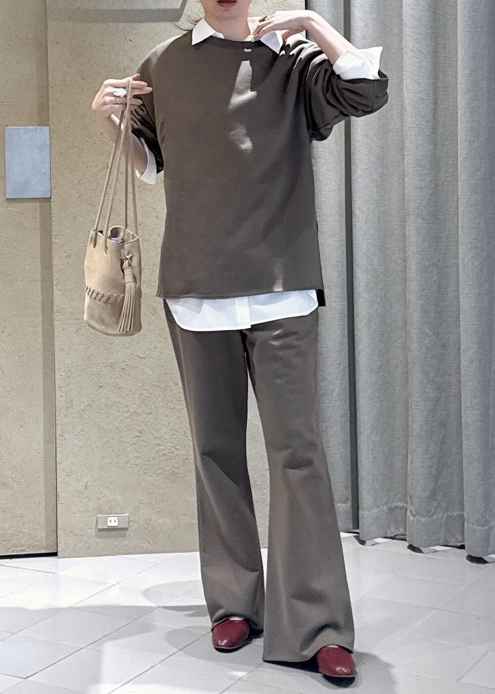 ホワイト系のシャツ/ブラウス、ホワイト系のショルダーバッグ、ブラウン系のスウェットを着用したレディースの春コーディネートの5枚目の写真