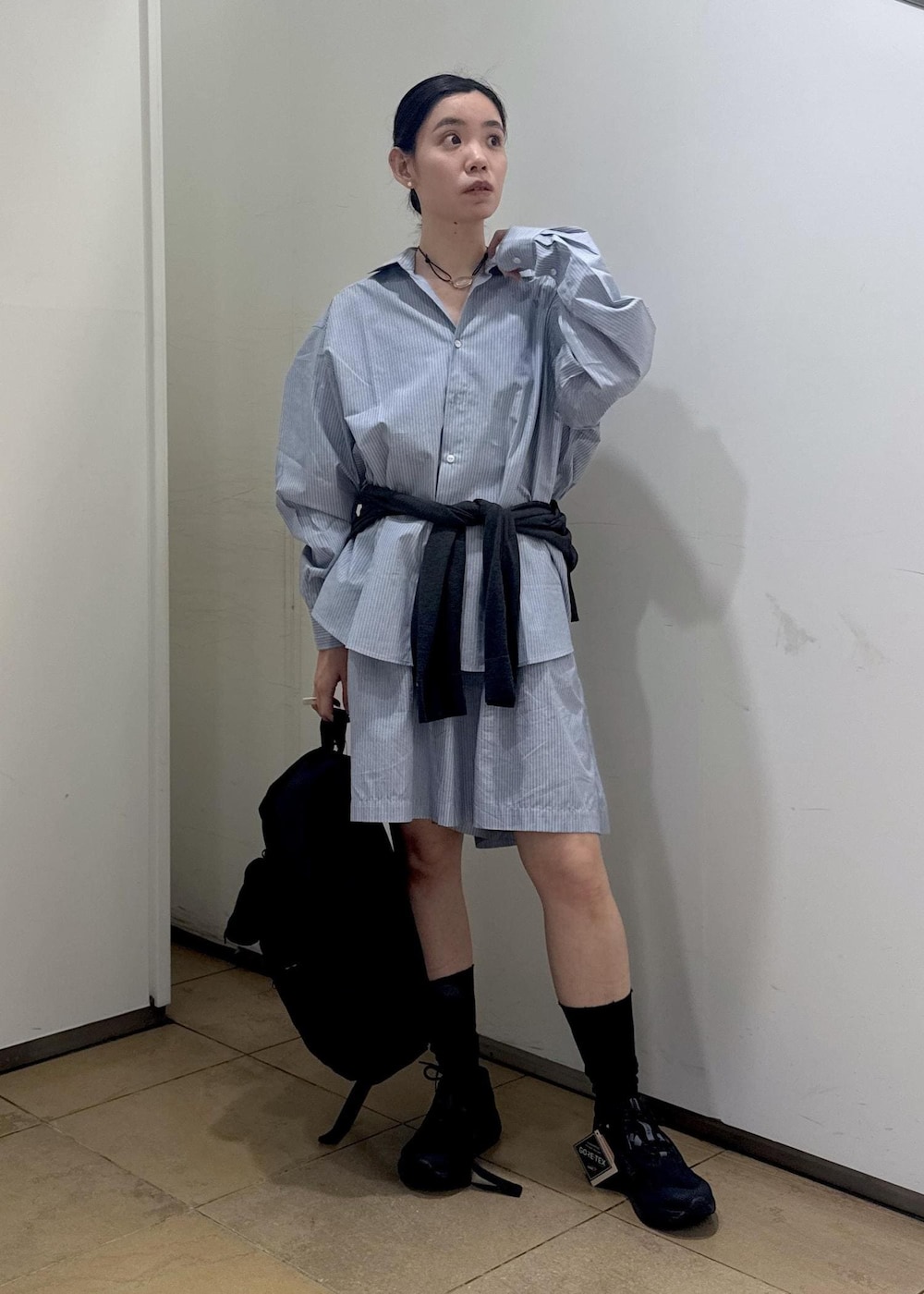 ブラック系のバックパック/リュック、ブラック系のスニーカーを着用したレディースの夏コーディネートの2枚目の写真