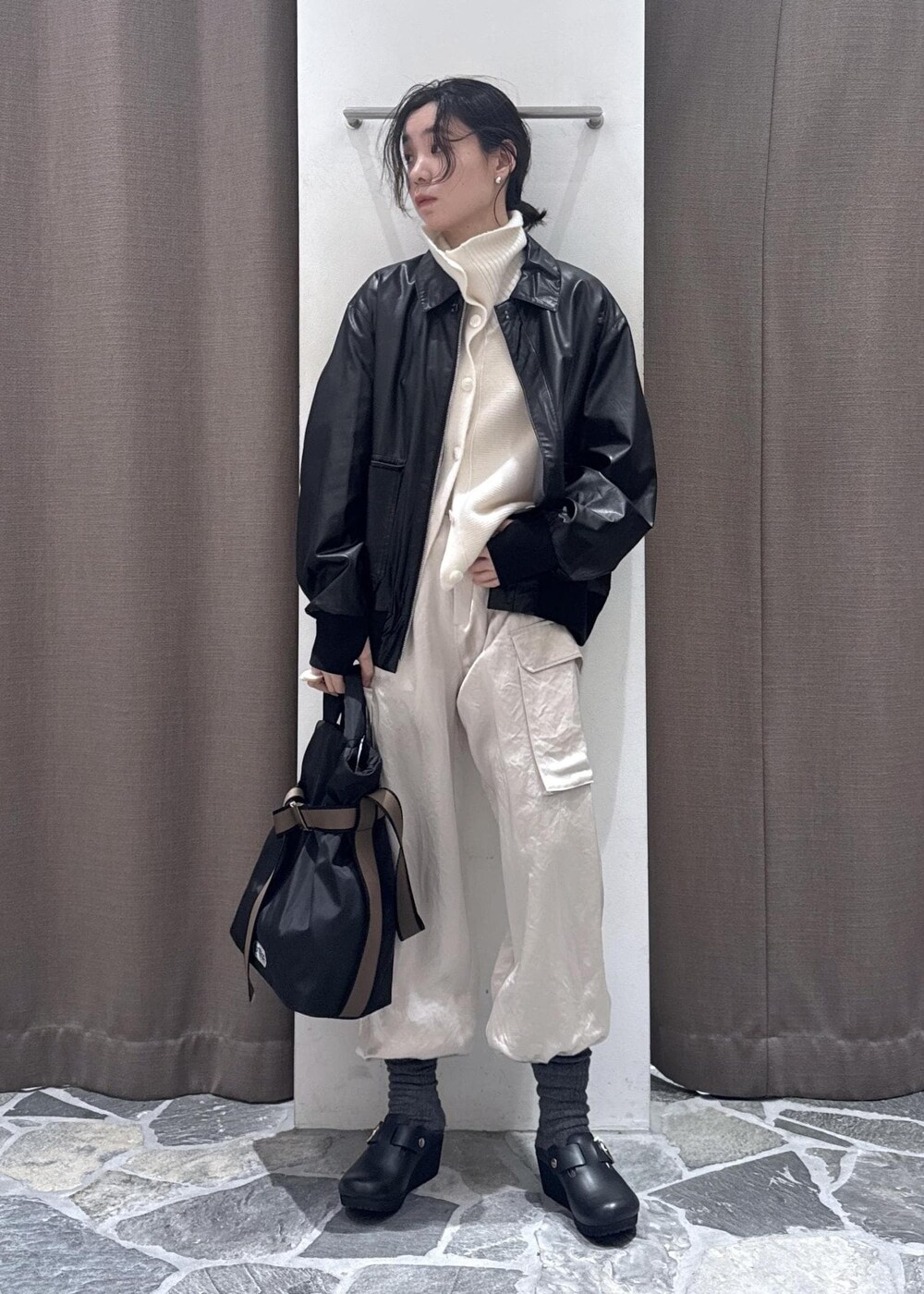 ホワイト系のカーゴパンツ、ブラック系のブルゾン、ホワイト系のカーディガン/ボレロを着用したレディースの冬コーディネートの6枚目の写真