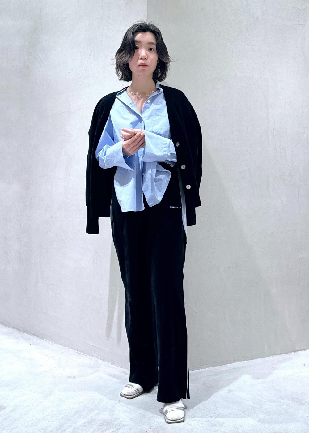 ブラック系のカーディガン/ボレロ、ブラック系のその他パンツ、ブルー系のシャツ/ブラウスを着用したレディースの冬コーディネートの3枚目の写真