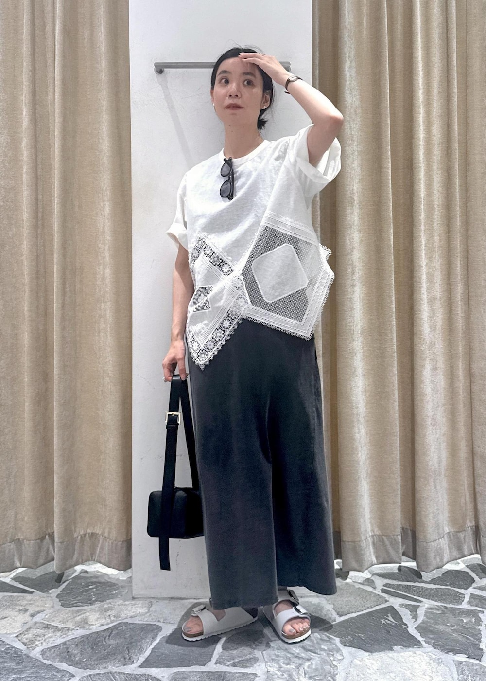 ブラック系のショルダーバッグ、ホワイト系のTシャツ/カットソー、グレー系のワンピースを着用したレディースの夏コーディネートの2枚目の写真