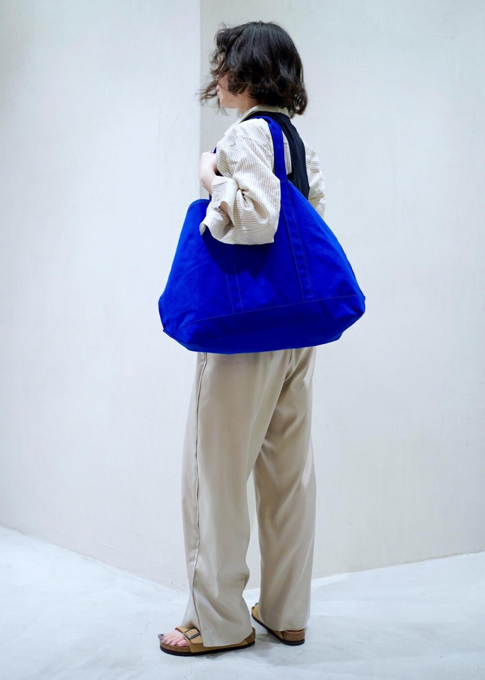 ホワイト系のシャツ/ブラウス、ベージュ系のその他パンツを着用したレディースの夏コーディネートの3枚目の写真