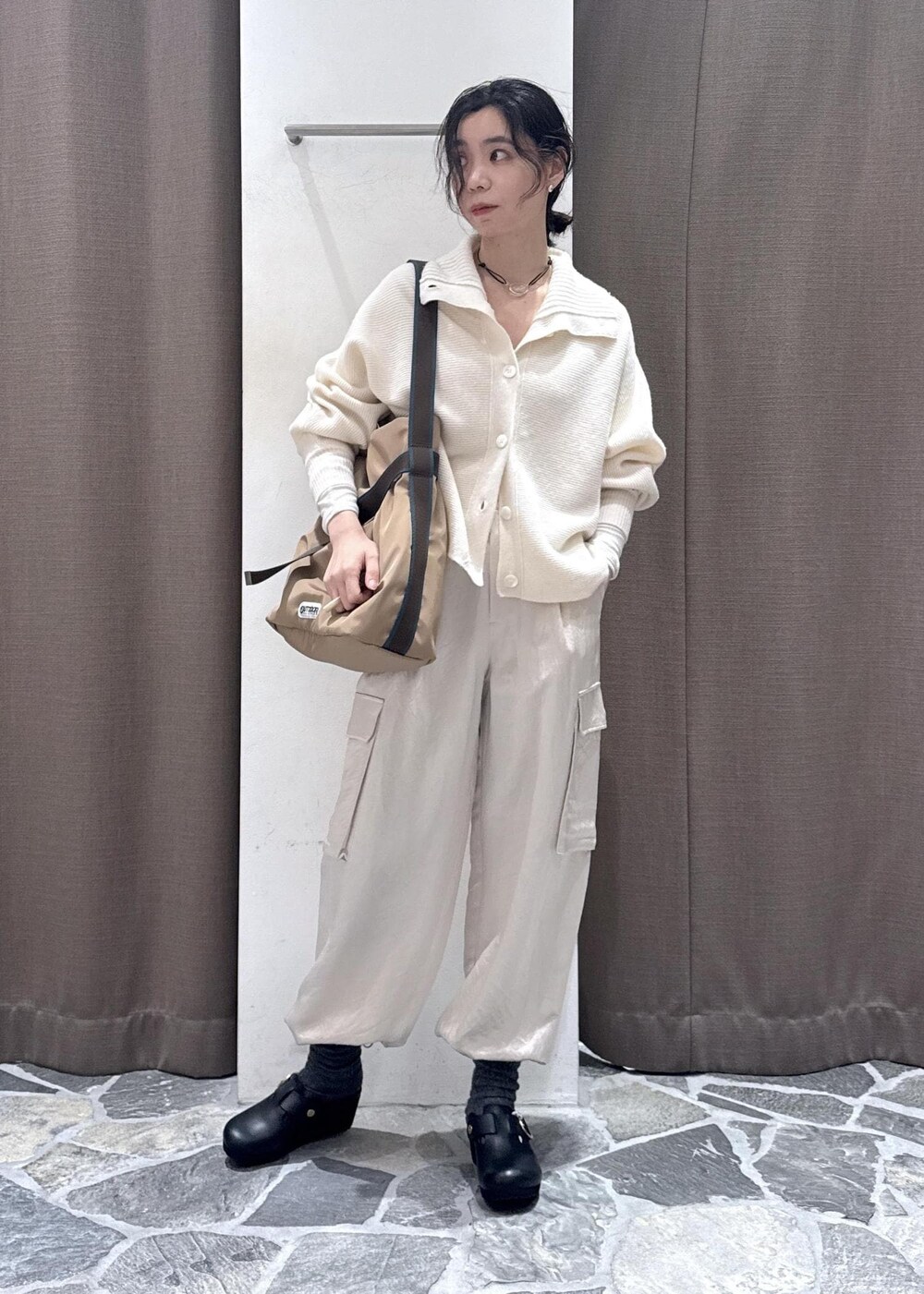 ホワイト系のカーディガン/ボレロ、ホワイト系のカーゴパンツ、ベージュ系のトートバッグを着用したレディースの冬コーディネートの2枚目の写真