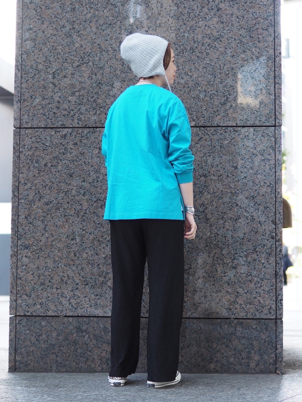 ブルー系のTシャツ/カットソー、ベージュ系のスニーカー、グレー系のニットキャップ/ビーニーを着用したレディースの秋コーディネートの2枚目の写真