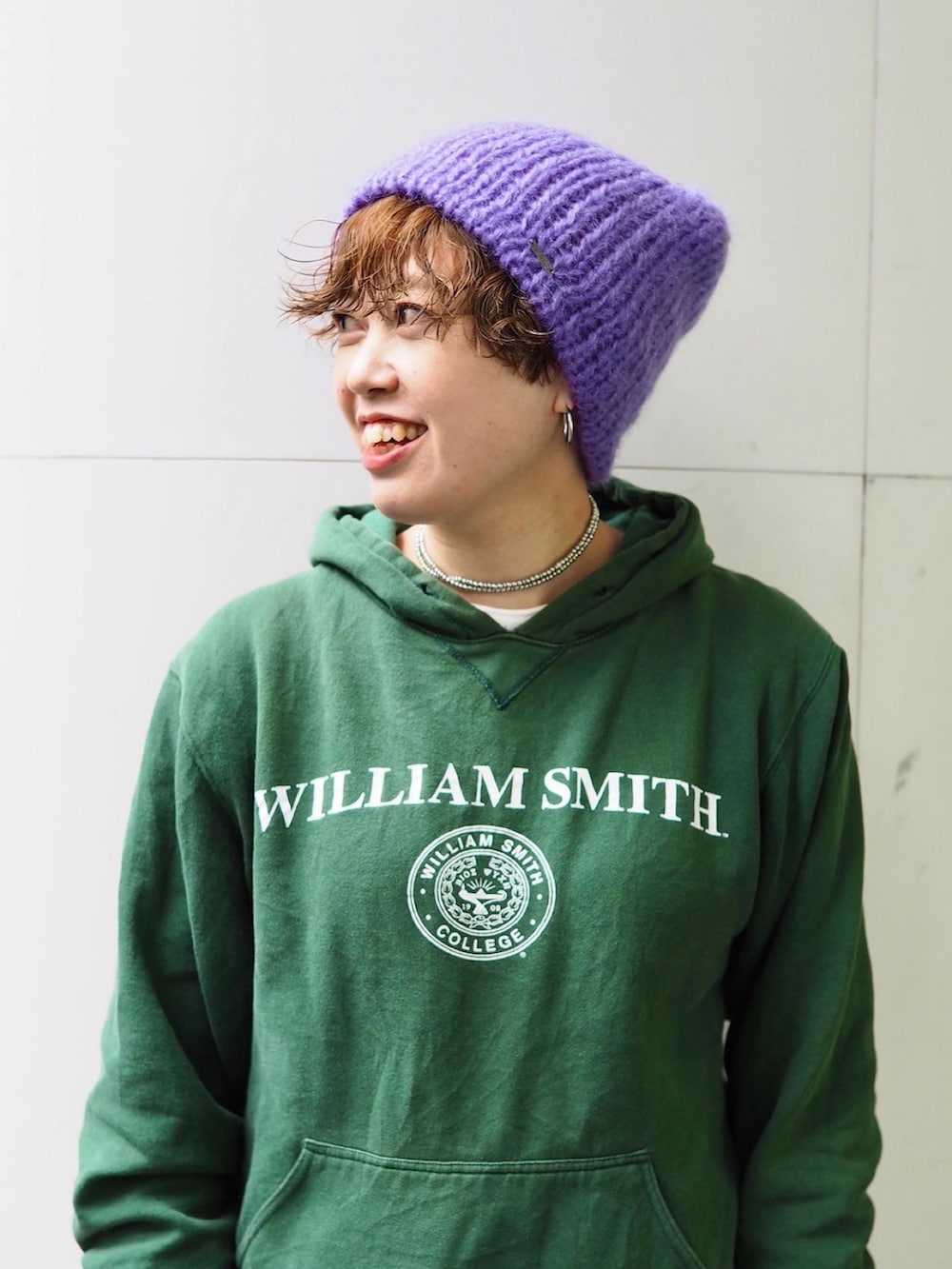 ブラック系のスニーカー、グリーン系のパーカー、パープル系の手袋を着用したレディースの冬コーディネートの2枚目の写真