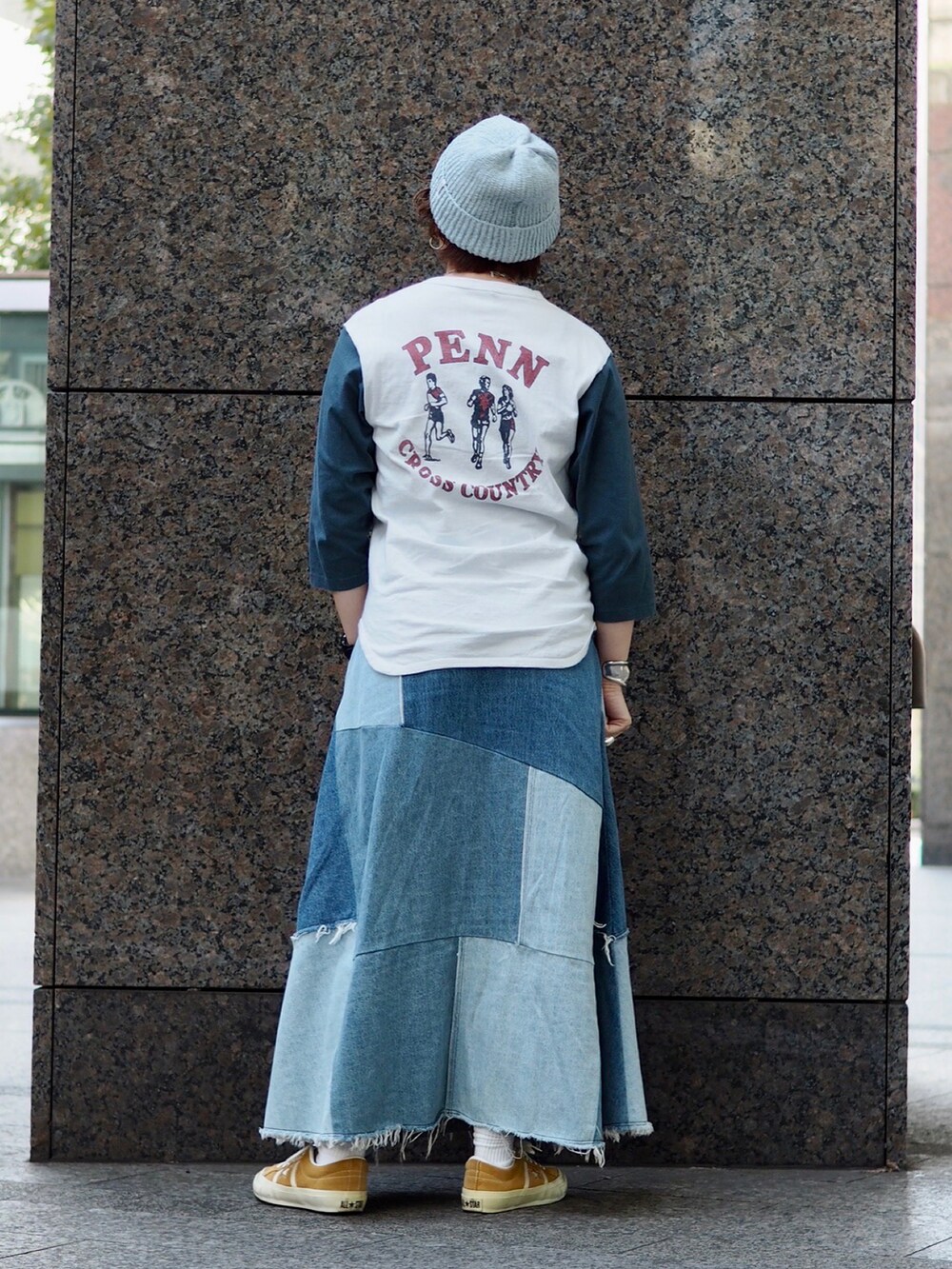 ブルー系のTシャツ/カットソー、ブルー系のデニムスカート、イエロー系のスニーカーを着用したレディースの冬コーディネートの2枚目の写真