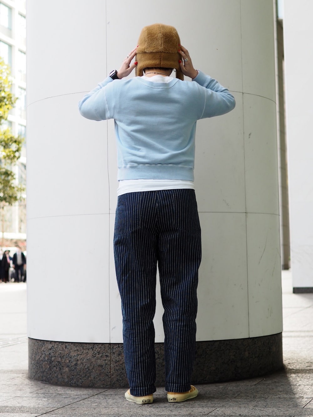 ブルー系のスウェット、ブルー系のデニムパンツ、イエロー系のスニーカーを着用したレディースの冬コーディネートの2枚目の写真