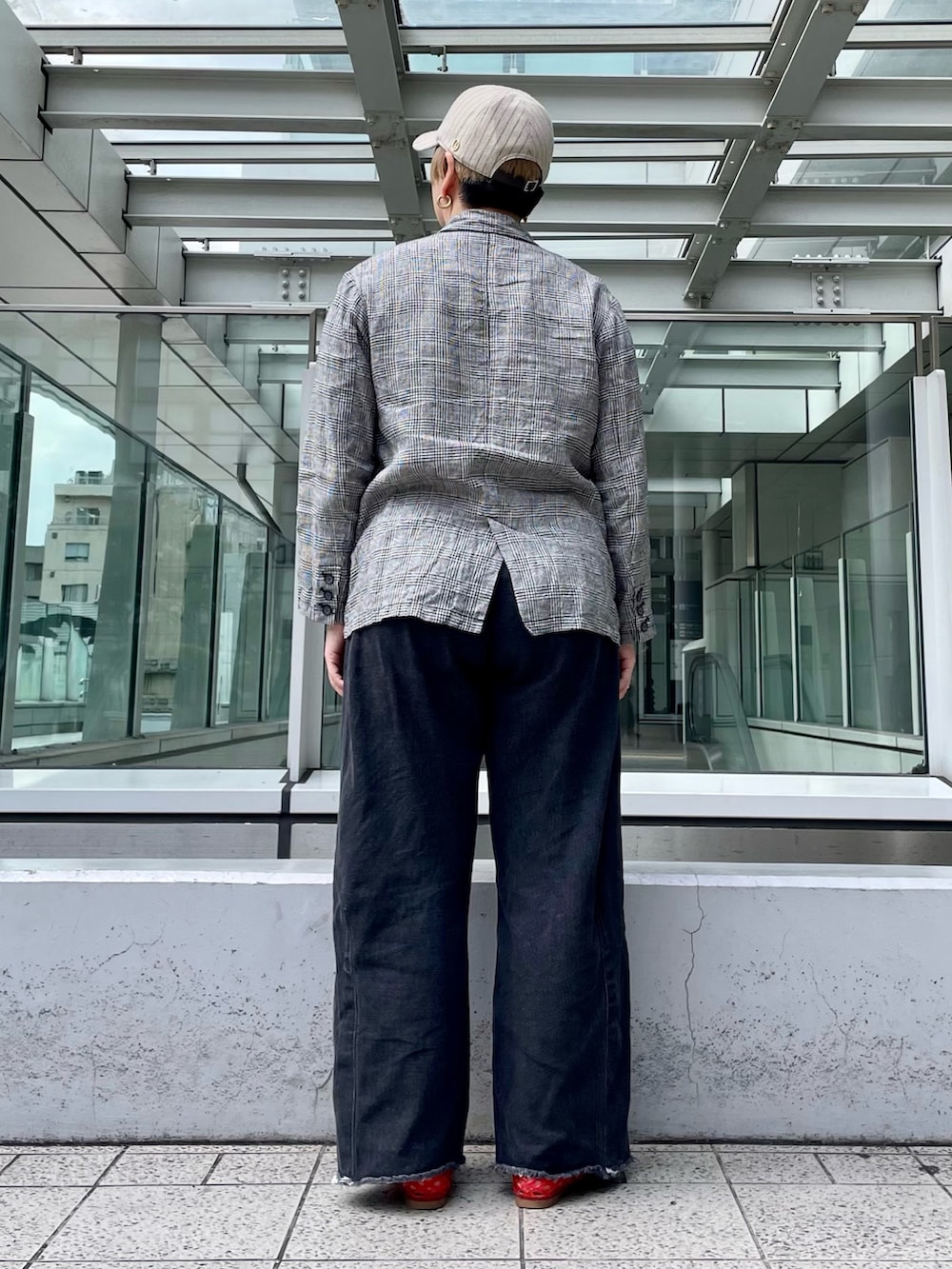 ブラック系のデニムパンツ、ブラック系のテーラードジャケット、ベージュ系のキャップを着用したレディースの夏コーディネートの4枚目の写真