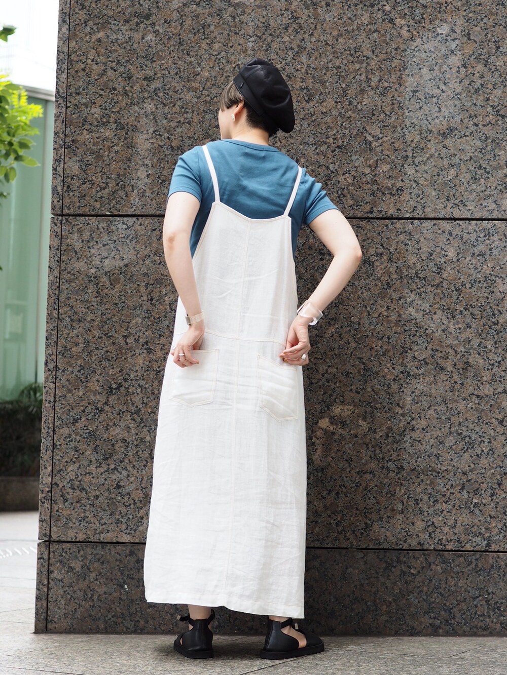 ブルー系のTシャツ/カットソー、ホワイト系のジャンパースカート、ブラック系のサンダルを着用したレディースの夏コーディネートの2枚目の写真