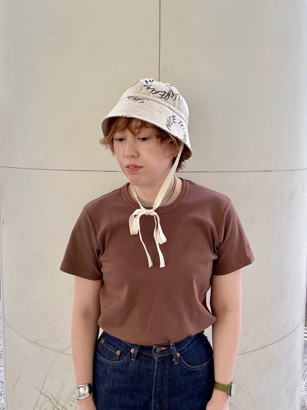 ブルー系のデニムパンツ、ブラック系のサンダル、シルバー系のバングル/リストバンドを着用したレディースの夏コーディネートの2枚目の写真