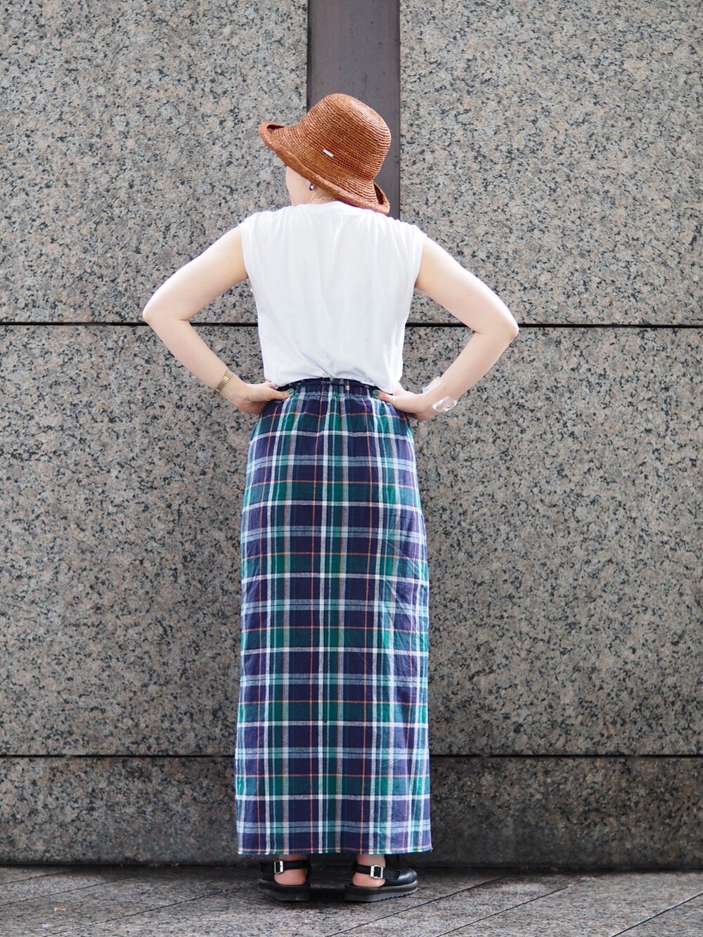 ブルー系のスカート、ブラック系のサンダル、シルバー系のネックレスを着用したレディースの春コーディネートの2枚目の写真