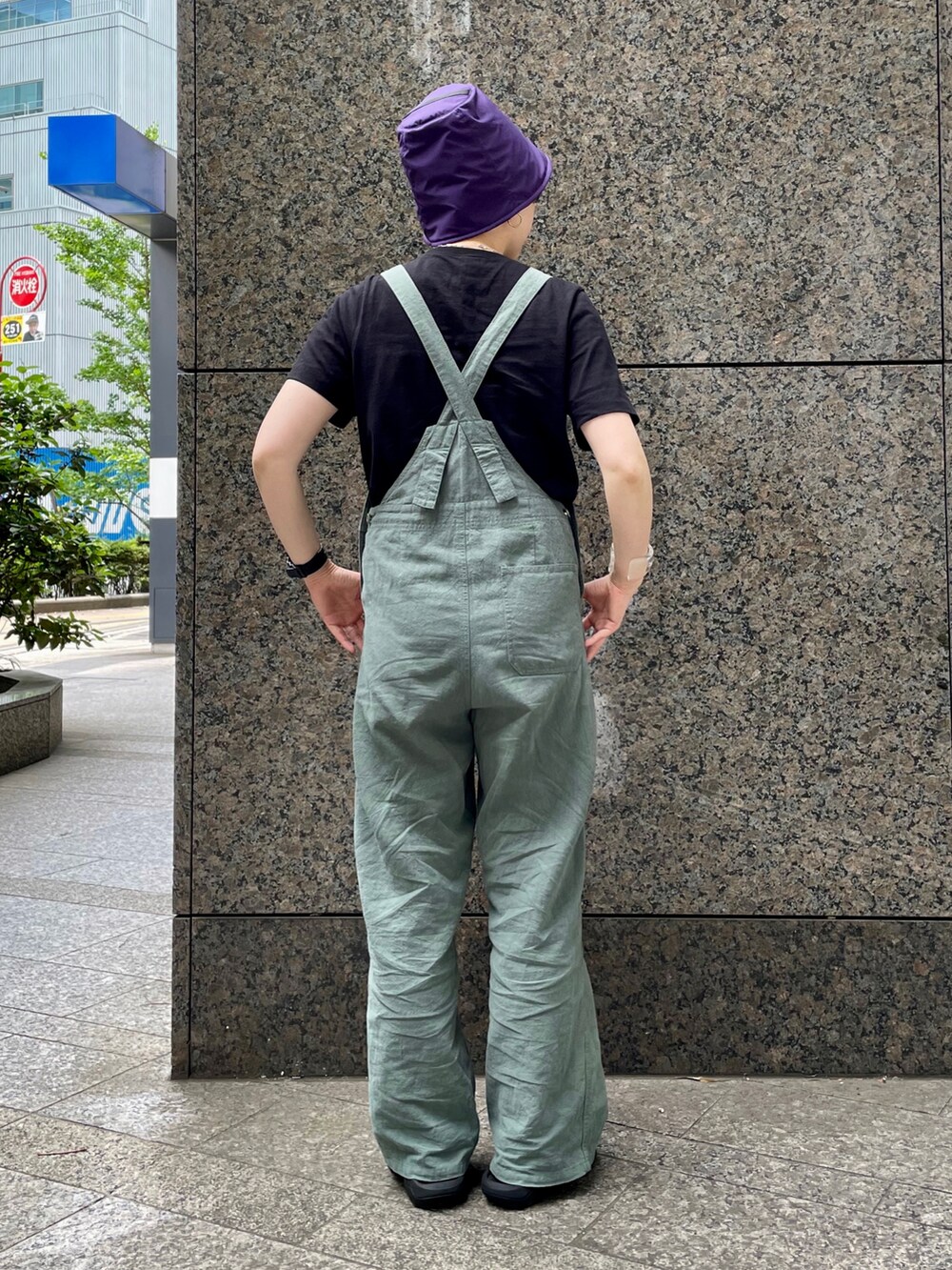 グリーン系のサロペット/オーバーオール、ブラック系のサンダル、パープル系のハットを着用したレディースの春コーディネートの2枚目の写真