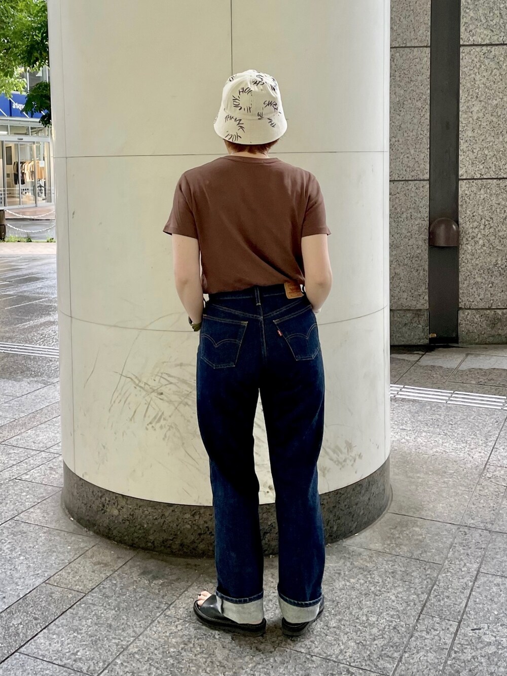 ブルー系のデニムパンツ、ブラック系のサンダル、シルバー系のバングル/リストバンドを着用したレディースの夏コーディネートの3枚目の写真