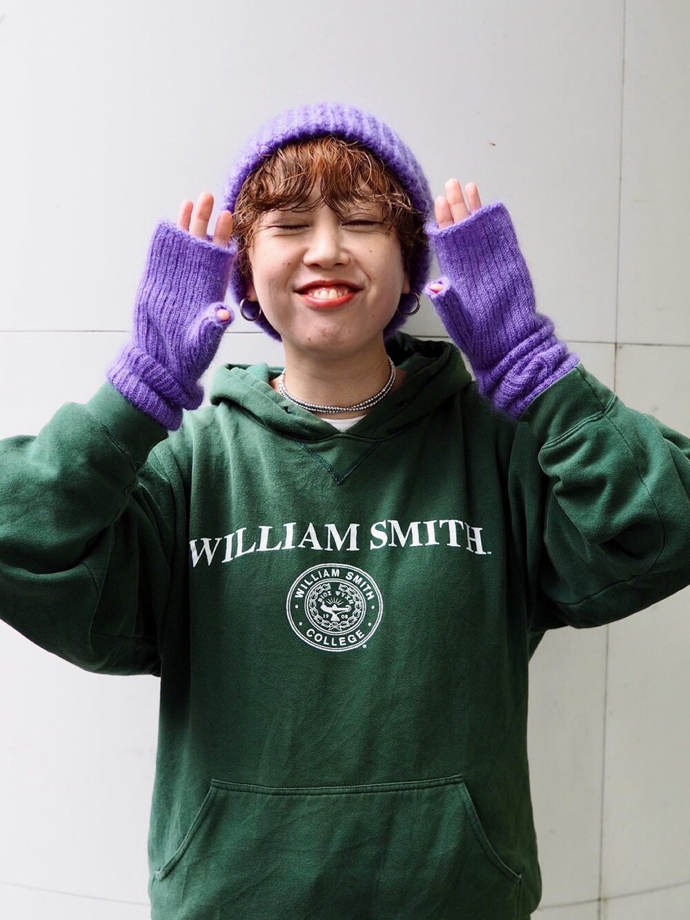 ブラック系のスニーカー、グリーン系のパーカー、パープル系の手袋を着用したレディースの冬コーディネートの3枚目の写真