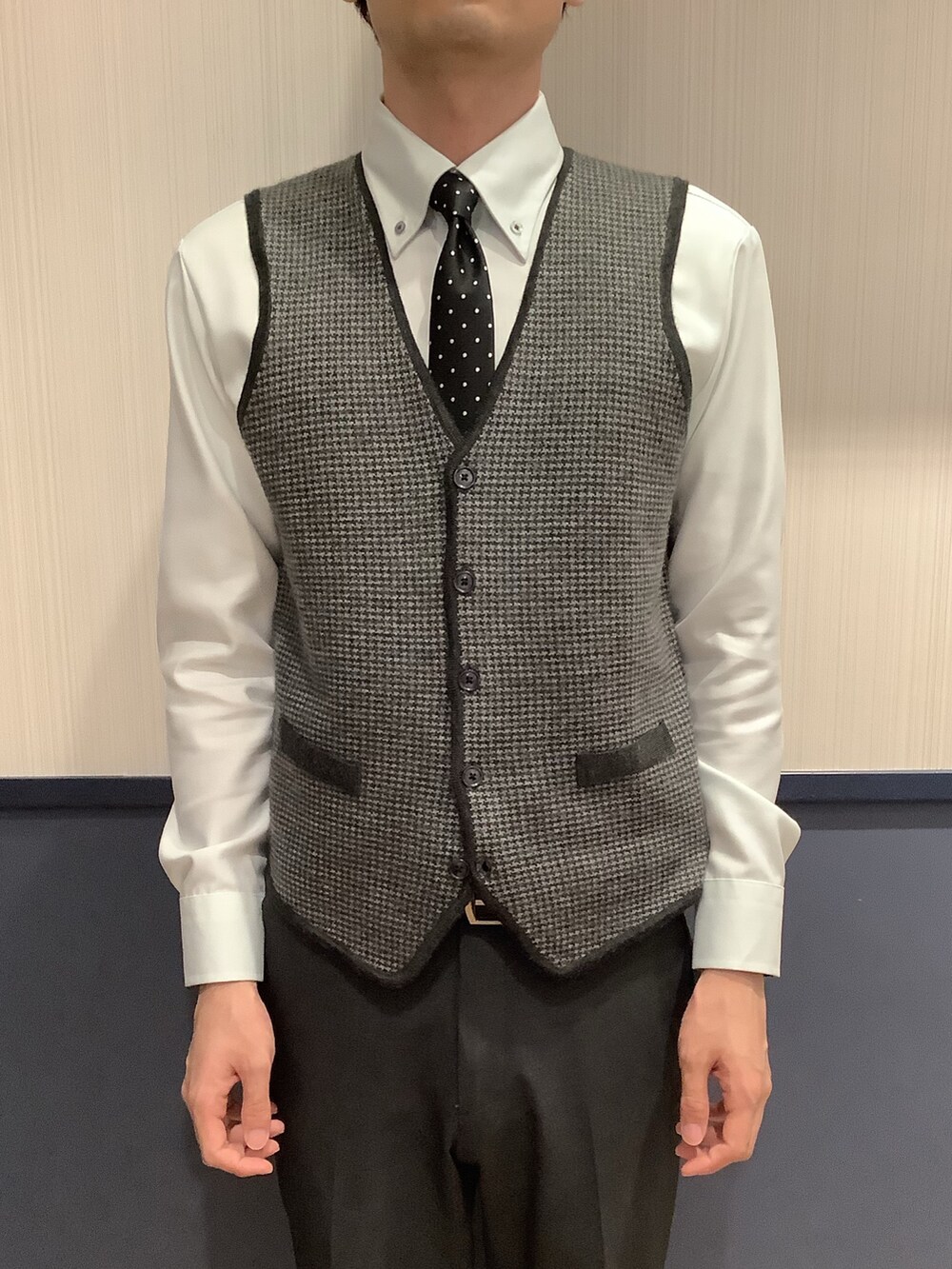 グリーン系のビジネスシャツ、グレー系のベストを着用したメンズの秋コーディネートの2枚目の写真