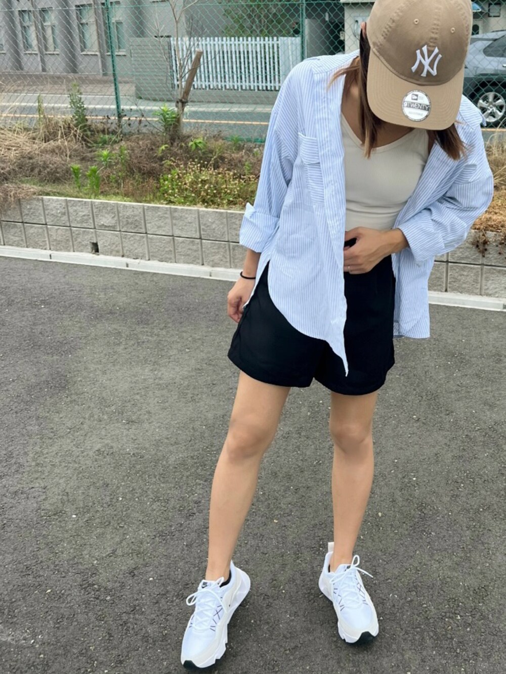 ホワイト系のスニーカー、ブラック系のパンツ、ブルー系のシャツ/ブラウスを着用したレディースの夏コーディネートの3枚目の写真