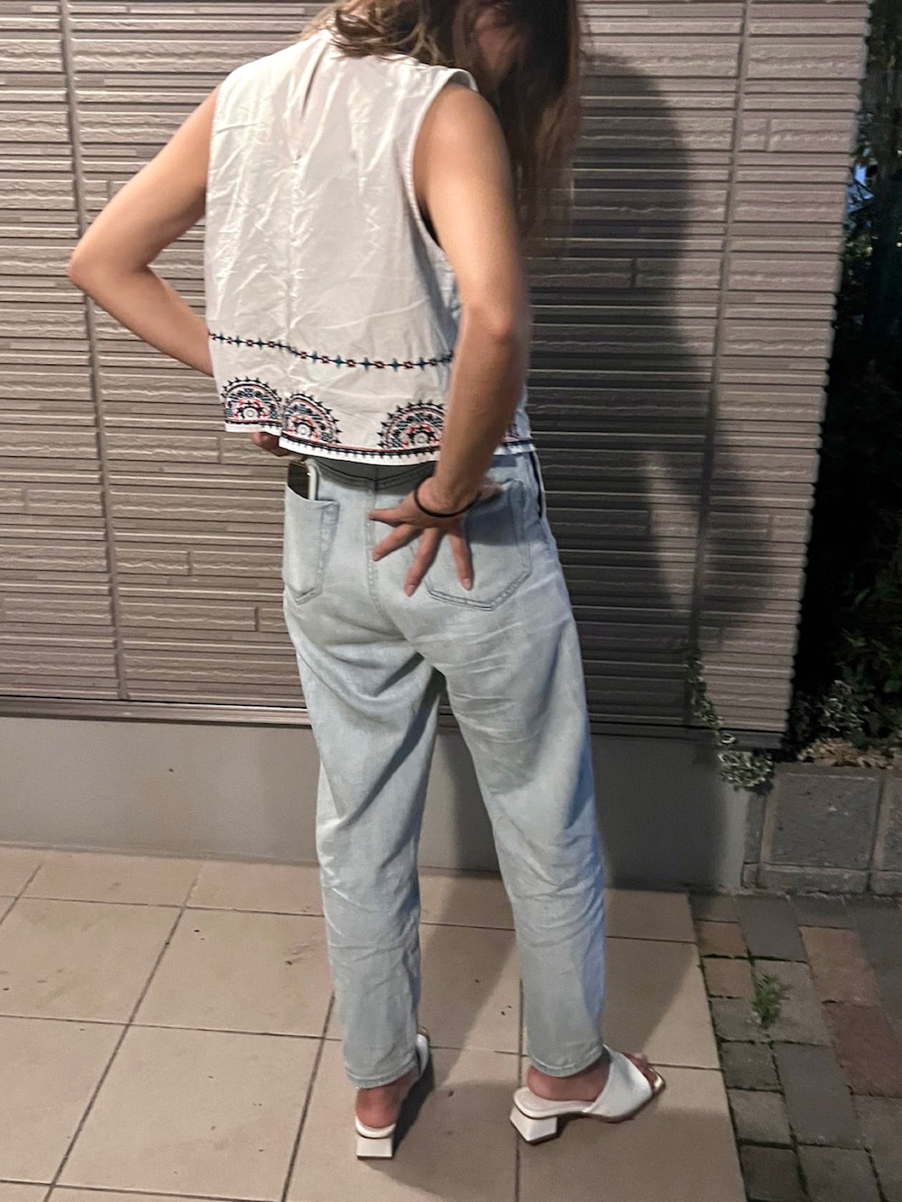 ホワイト系のサンダル、ブルー系のデニムパンツを着用したレディースの夏コーディネートの2枚目の写真