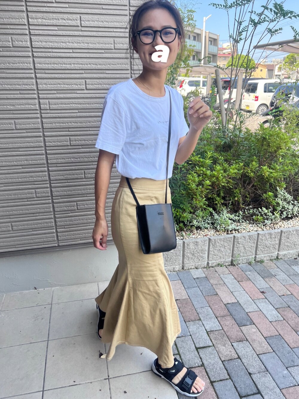 ブラック系のサンダル、ホワイト系のTシャツ/カットソー、ベージュ系のスカートを着用したレディースの夏コーディネートの3枚目の写真